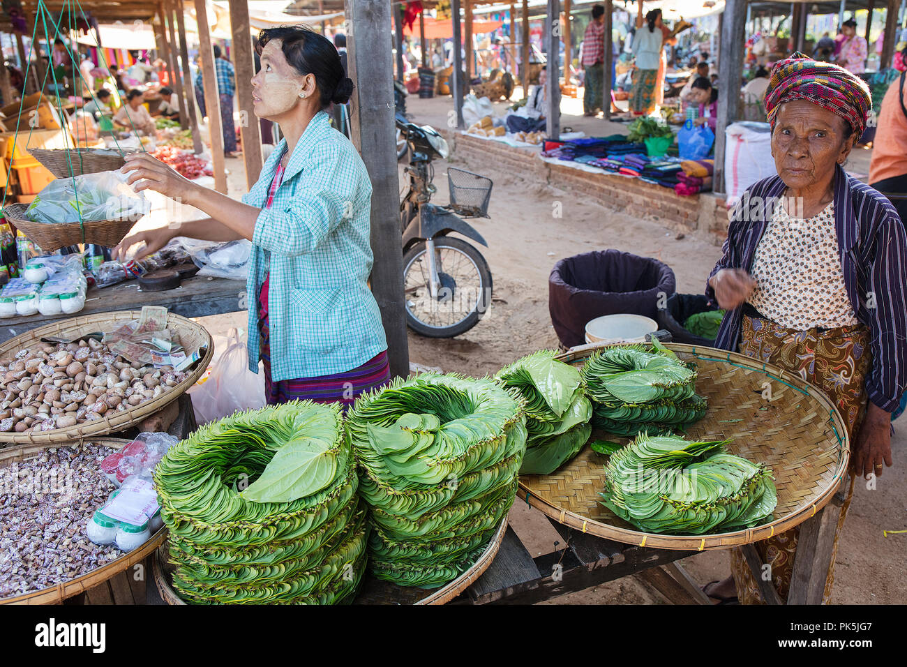 Les clients et les vendeurs interagissent dans un stand de légumes d'un marché local. Bagan, Myanmar (Birmanie). Banque D'Images