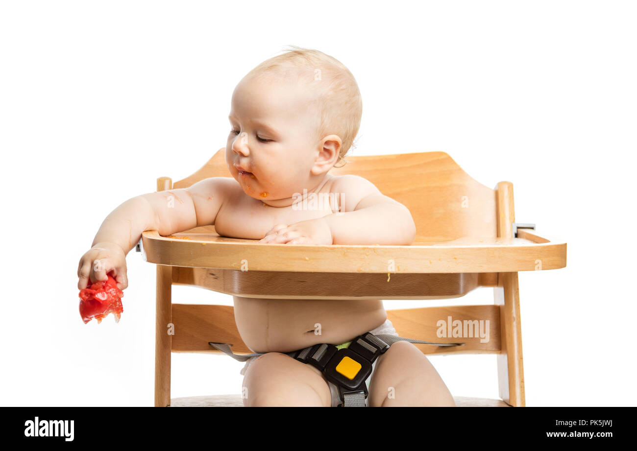 Mignon bébé fille qui va à la tomate chute alors qu'il était assis dans une chaise  haute sur fond blanc Photo Stock - Alamy