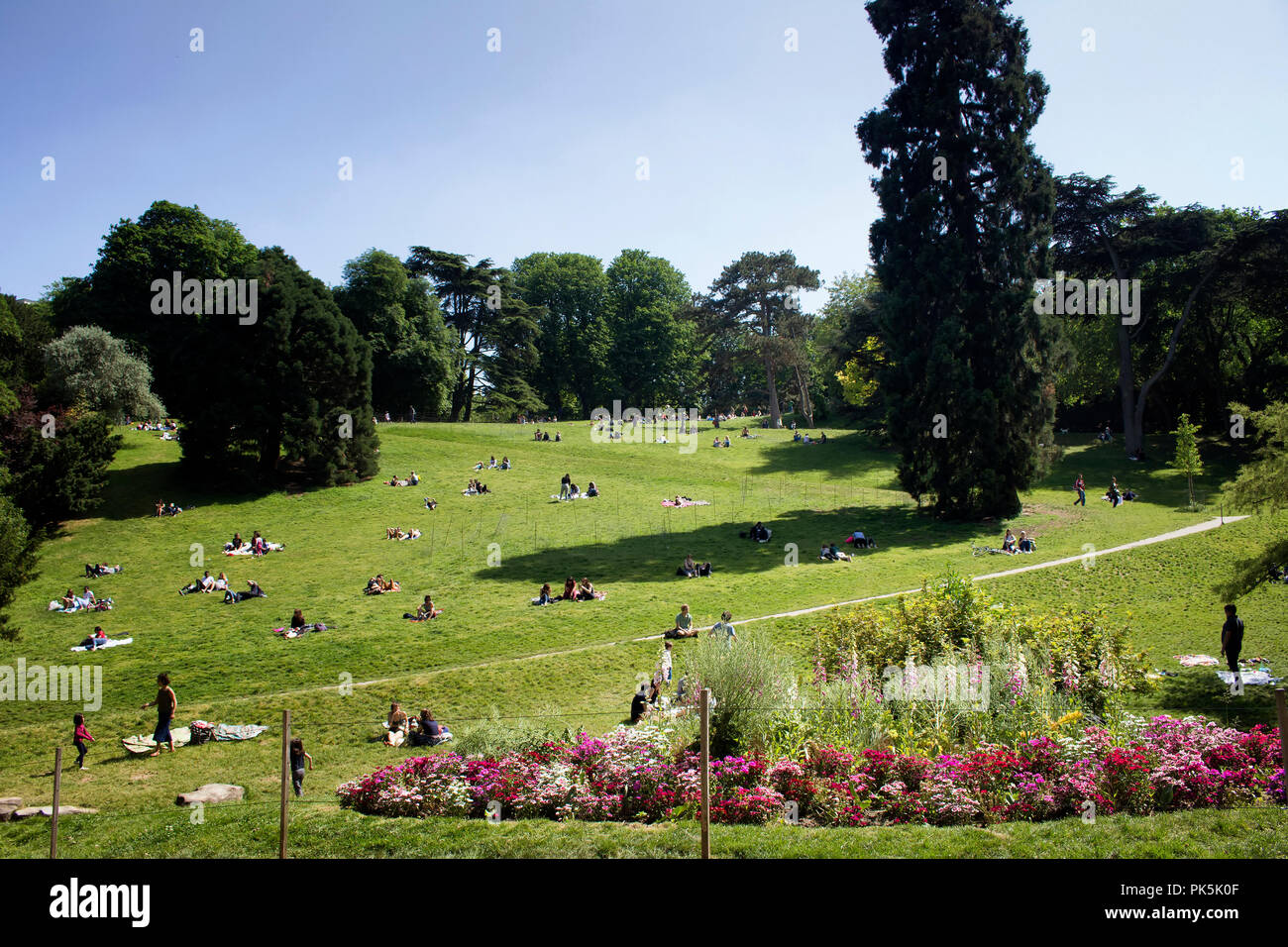 Les gens profiter du beau temps et du Park (Parc des Buttes-Chaumont) à Paris. C'est un jour de printemps ensoleillé. Banque D'Images