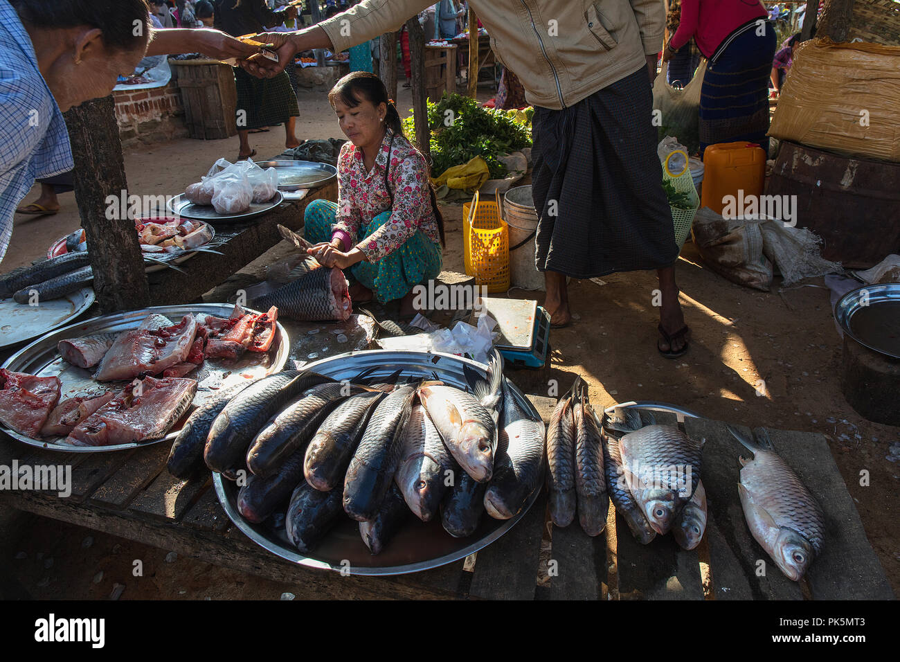 Un client paye dans un peuplement de poissons d'un marché. Bagan, Myanmar (Birmanie). Banque D'Images