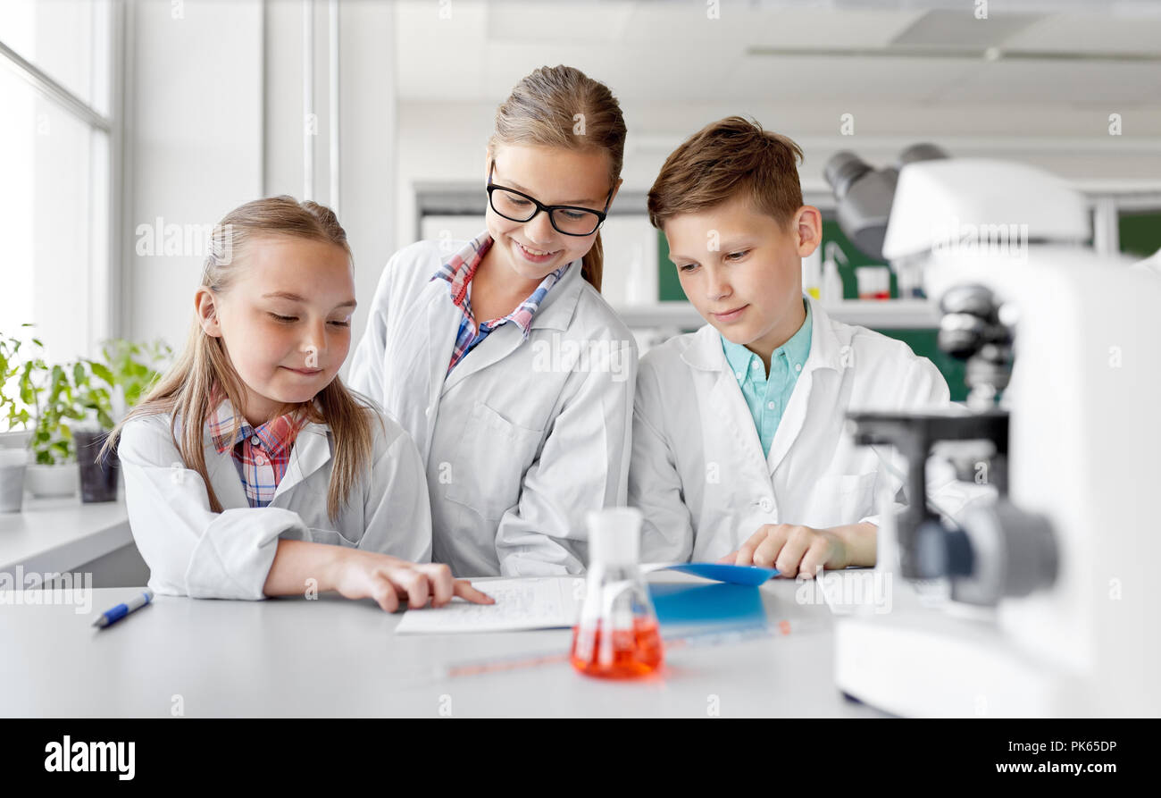 Les enfants qui étudient la chimie à laboratoire d'école Banque D'Images