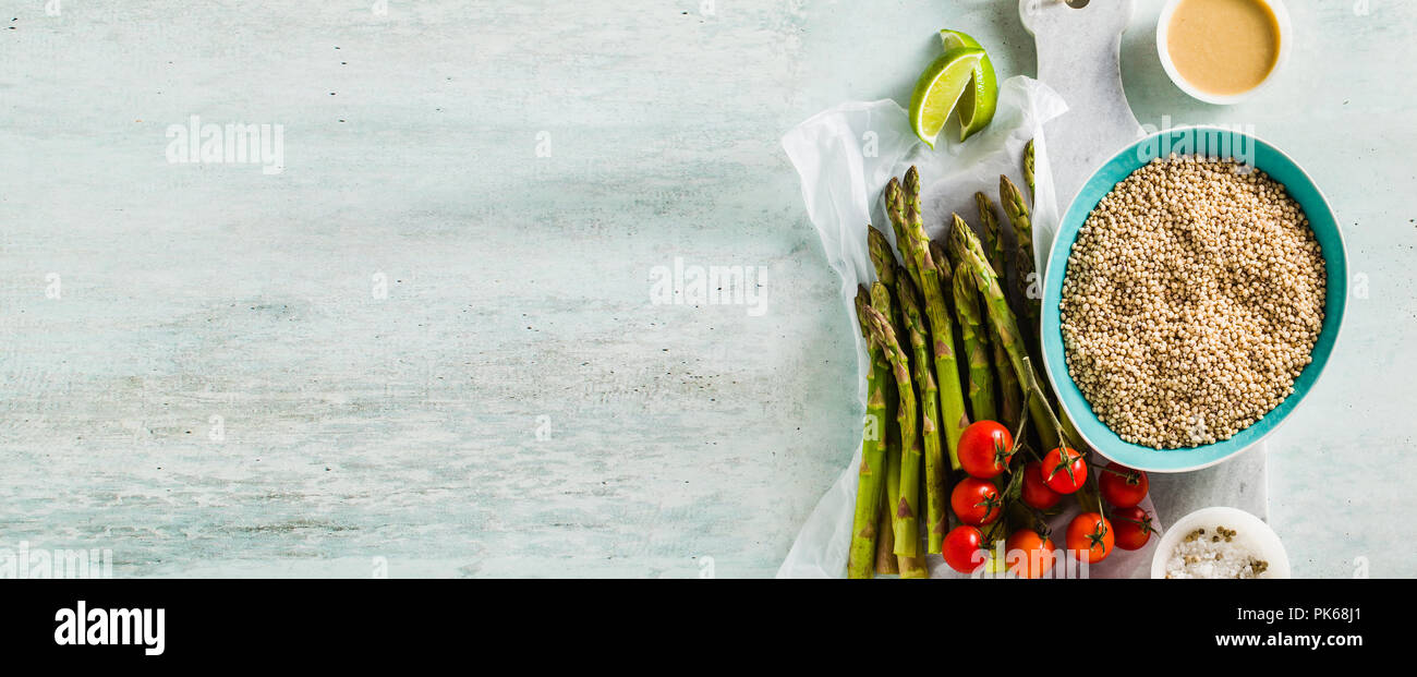 Bannière de sorgho ou grand milet aux asperges vertes et tomates cerises sur la table. Ingrédients pour des recettes sans gluten pour une cuisine saine. Banque D'Images