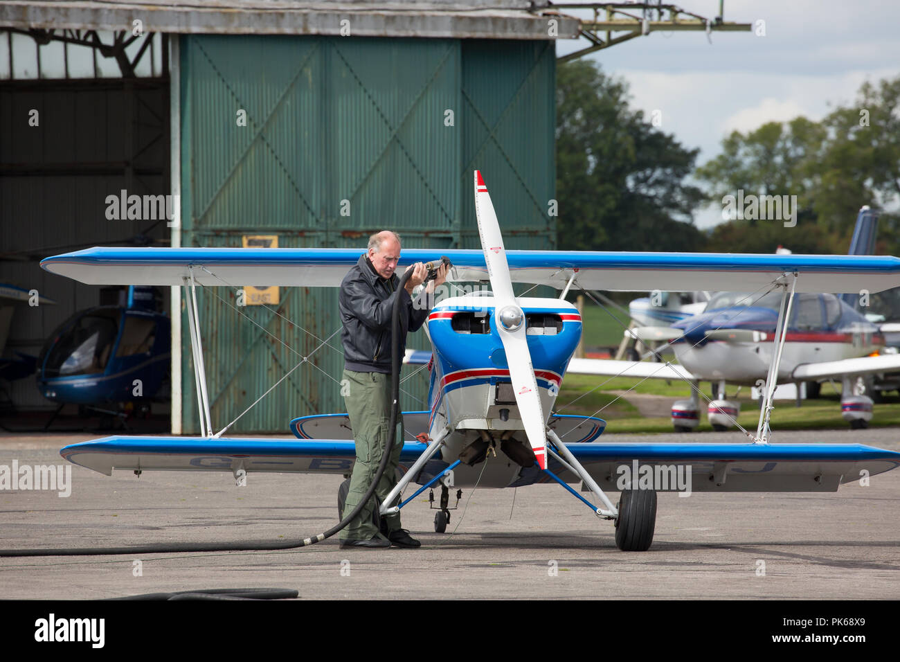 Photo de paysage de l'homme de race blanche d'âge moyen petit avion biplan ravitaillement vintage Bobbington, aérodrome, Staffordshire, Royaume-Uni. Banque D'Images