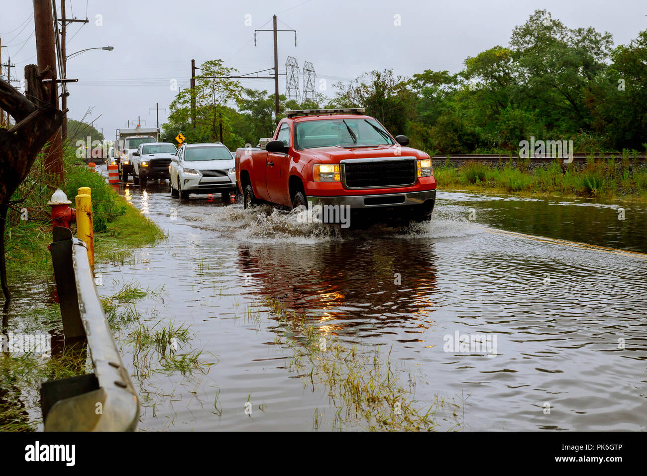 Voiture roulant à travers l'eau d'inondation de la route pendant la saison de mousson Banque D'Images