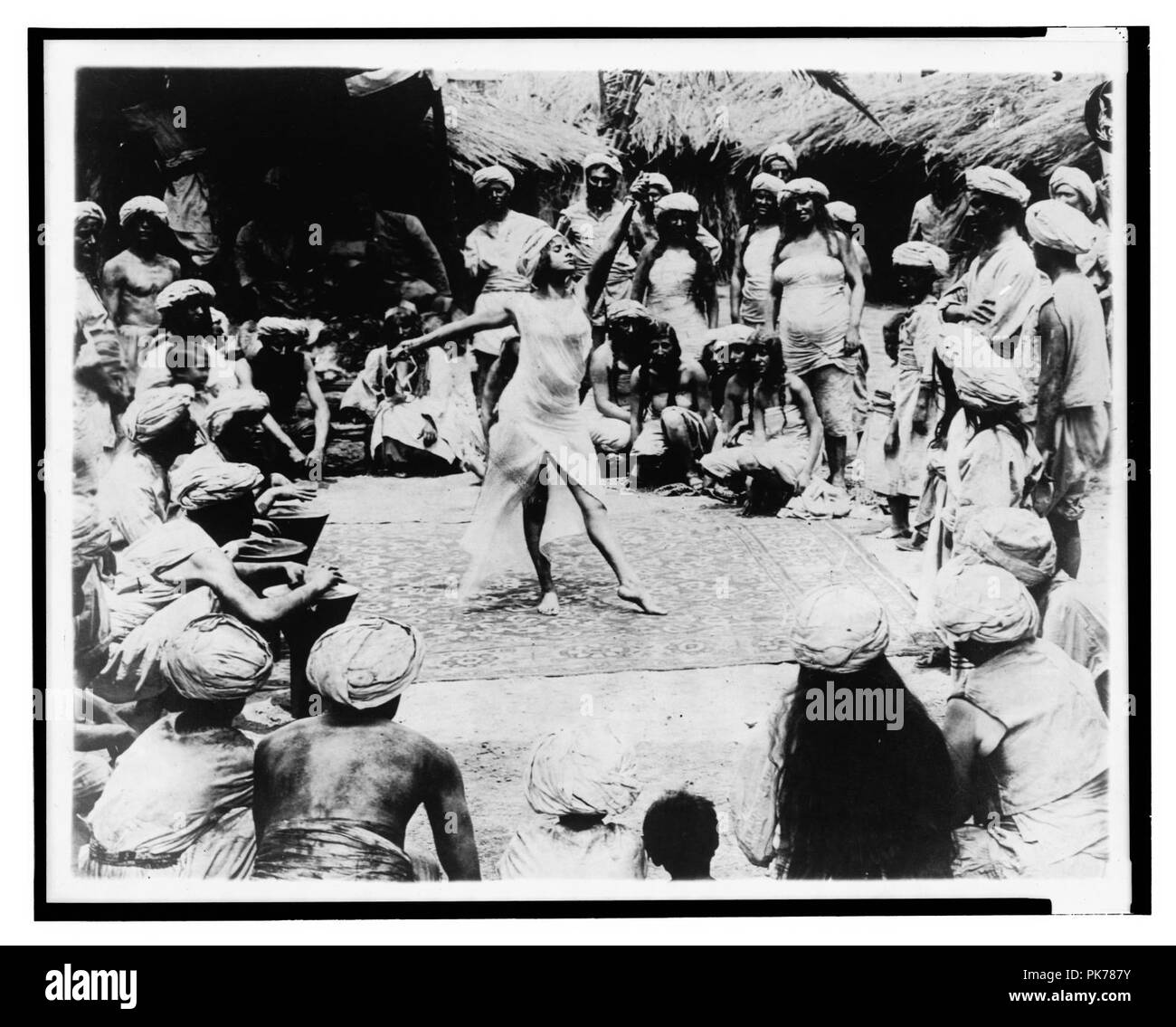 Entre savage et tigre. Nautch girl dancing sur tapis avec des hommes et des femmes regardant hindou Banque D'Images