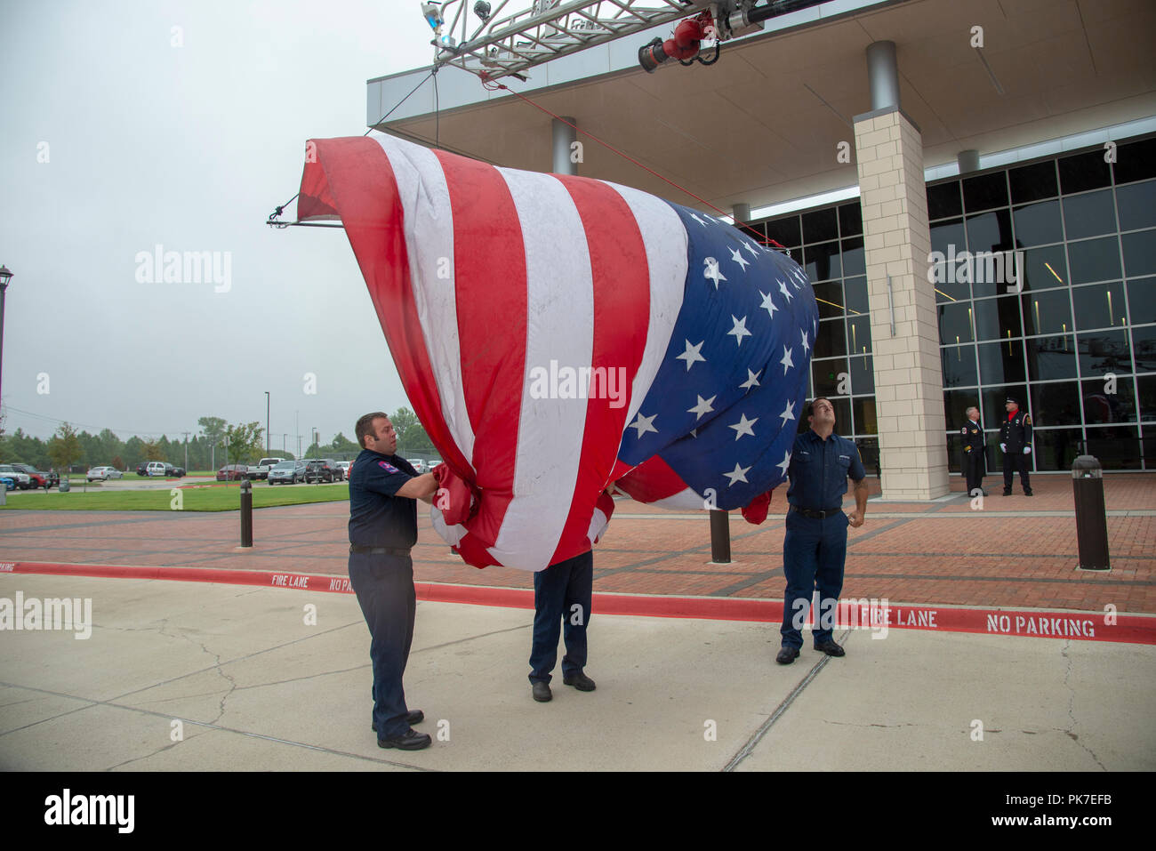 McKinney, USA. 11 septembre : un jour du Souvenir. Les pompiers dans la ville de McKinney, Texas du nord, préparer d'accrocher un grand drapeau américain à partir de l'échelle de leur camion à incendie dans la mémoire de ceux qui ont perdu la vie dans le 11 septembre 2001 attaque terroriste sur le World Trade Center à New York et le Pentagone à Washington D.C. Crédit : Nick Young/Alamy Live News Banque D'Images