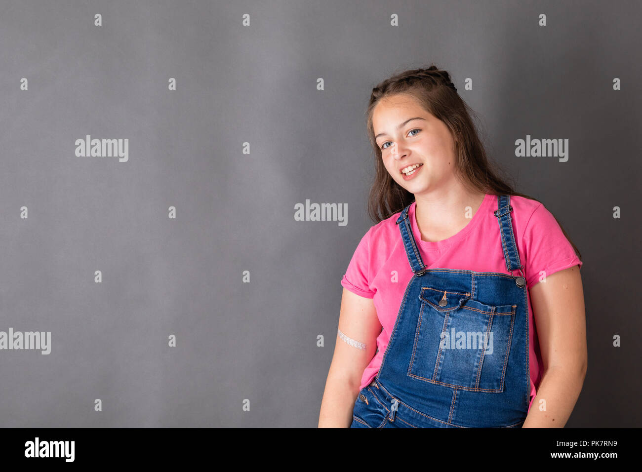 Confiant smiling girl student sur fond gris Banque D'Images