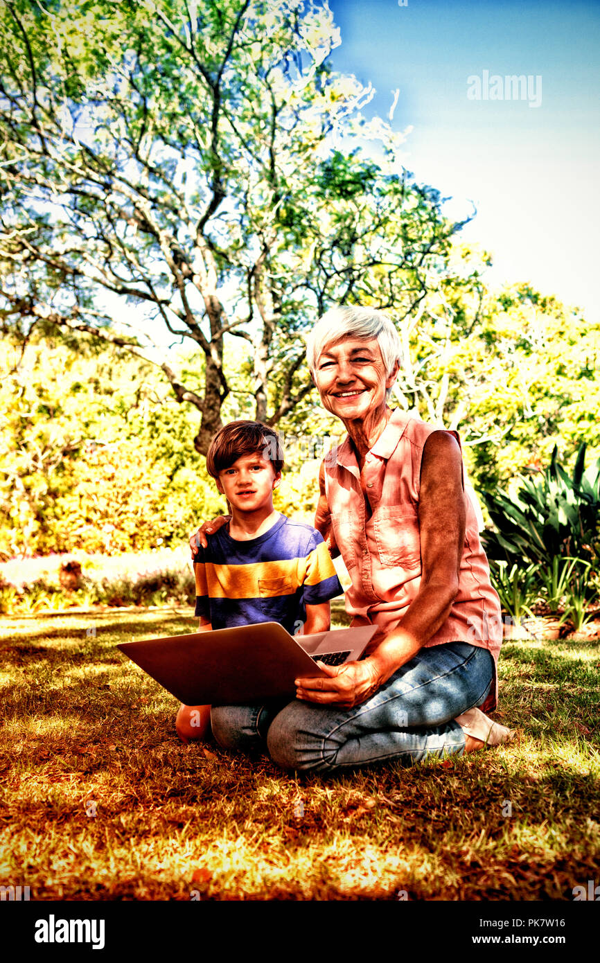 Grand-mère et petit-fils using laptop in the park Banque D'Images