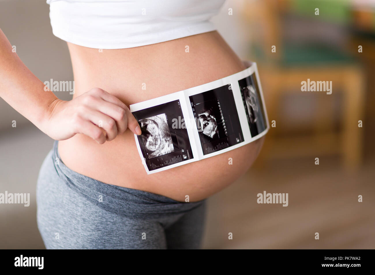 Pregnant woman holding ultrasound photo sur ventre Banque D'Images