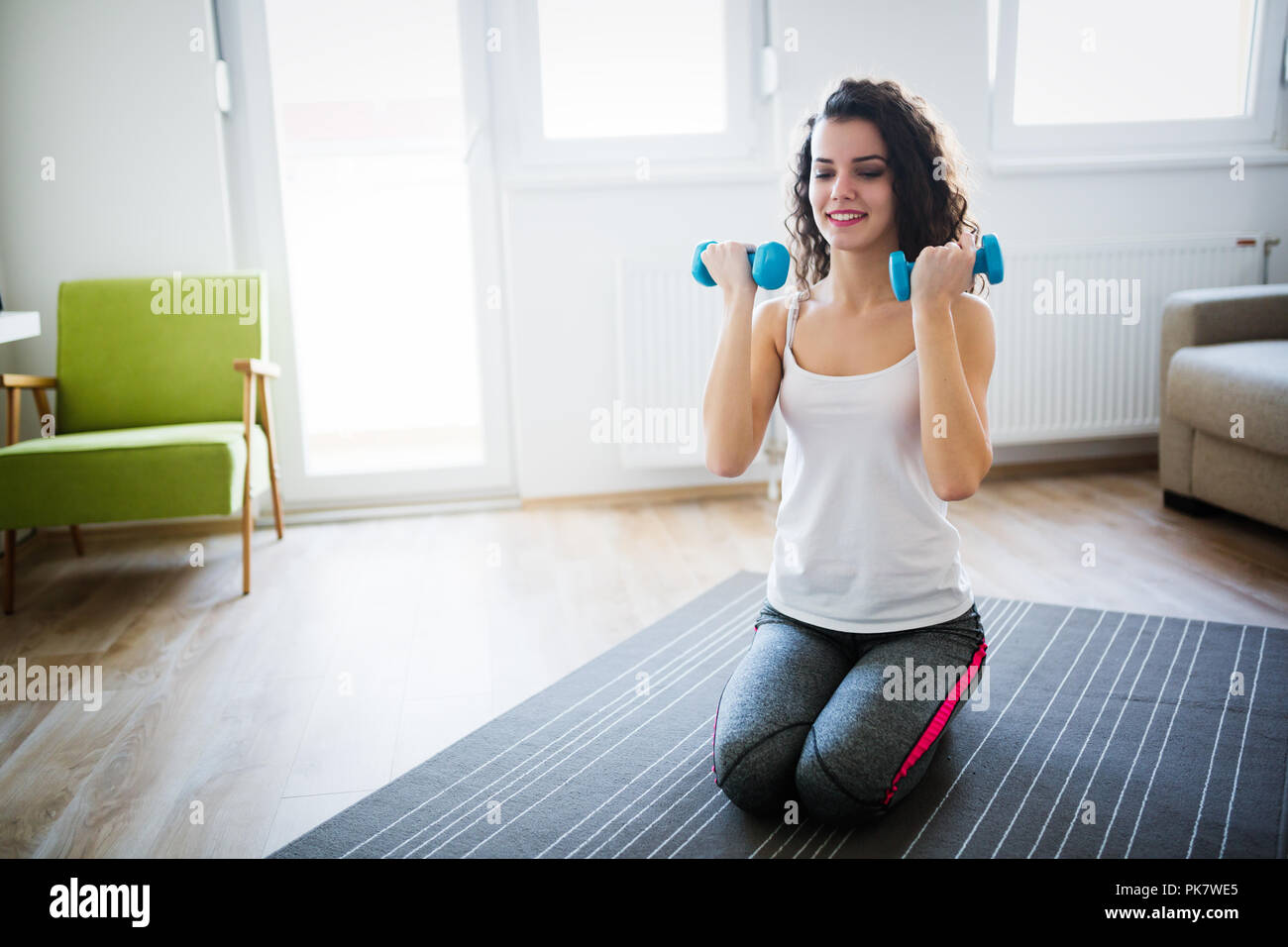 Young attractive de la sportive faisant des exercices à la maison Banque D'Images