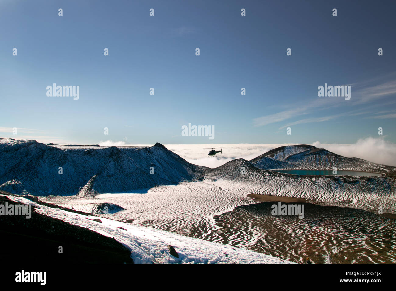 Vue panoramique des montagnes sauvages paysage de neige avec Deep Blue Lake au-dessus des nuages et de sauvetage-l'épargne trampers, Nouvelle-Zélande Banque D'Images