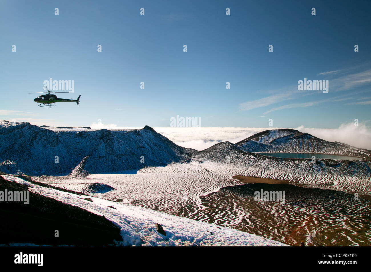 Le Bivouac de sauvetage par hélicoptère dans la région de montagnes sauvages paysage de neige avec Deep Blue Lake au-dessus des nuages, en secourant trampers, Parc National de Tongariro Banque D'Images