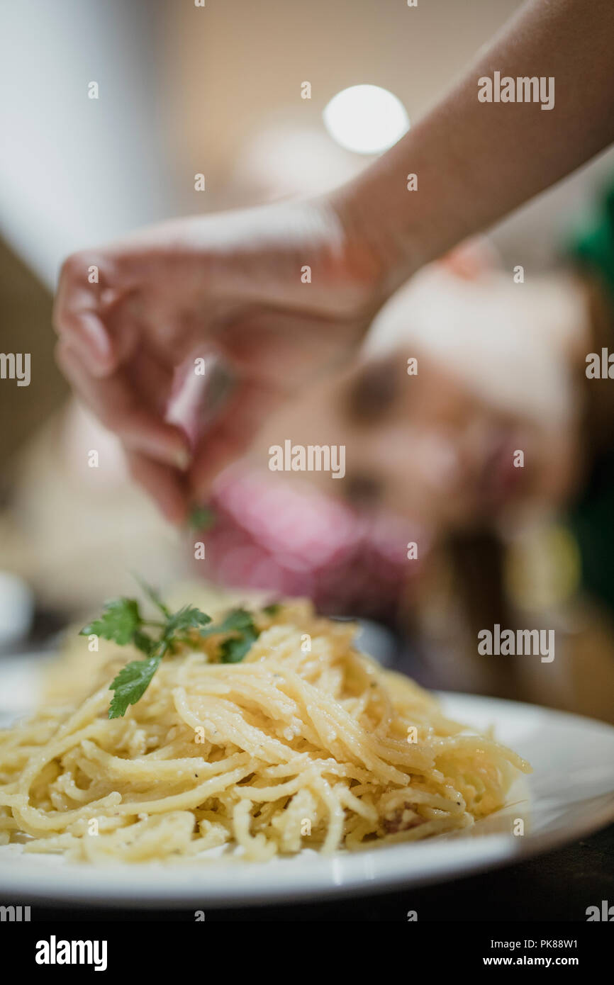 Rapprochée sur des spaghetti carbonara avec de la coriandre est ajouté sur le dessus. Banque D'Images