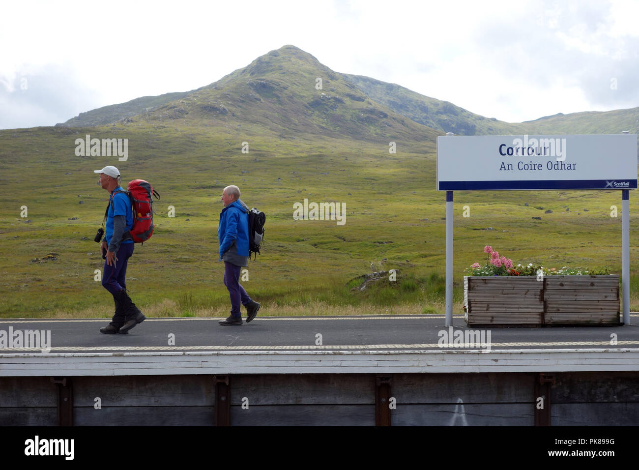 Deux hommes marchant à Corrour (Une Coire Odhar) Gare et la montagne Corbett Leum Uilleim écossais dans les Highlands, Ecosse, Royaume-Uni. Banque D'Images