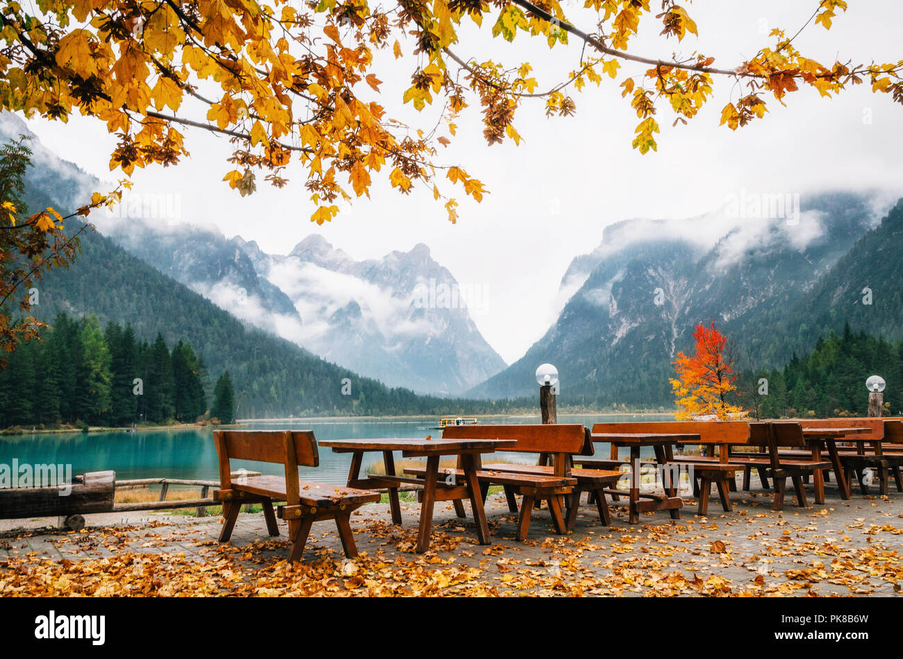 Lac Dobbiaco ou Toblacher en Dolomites avec tables et bancs en bois dans le café-restaurant en plein air à l'automne Banque D'Images