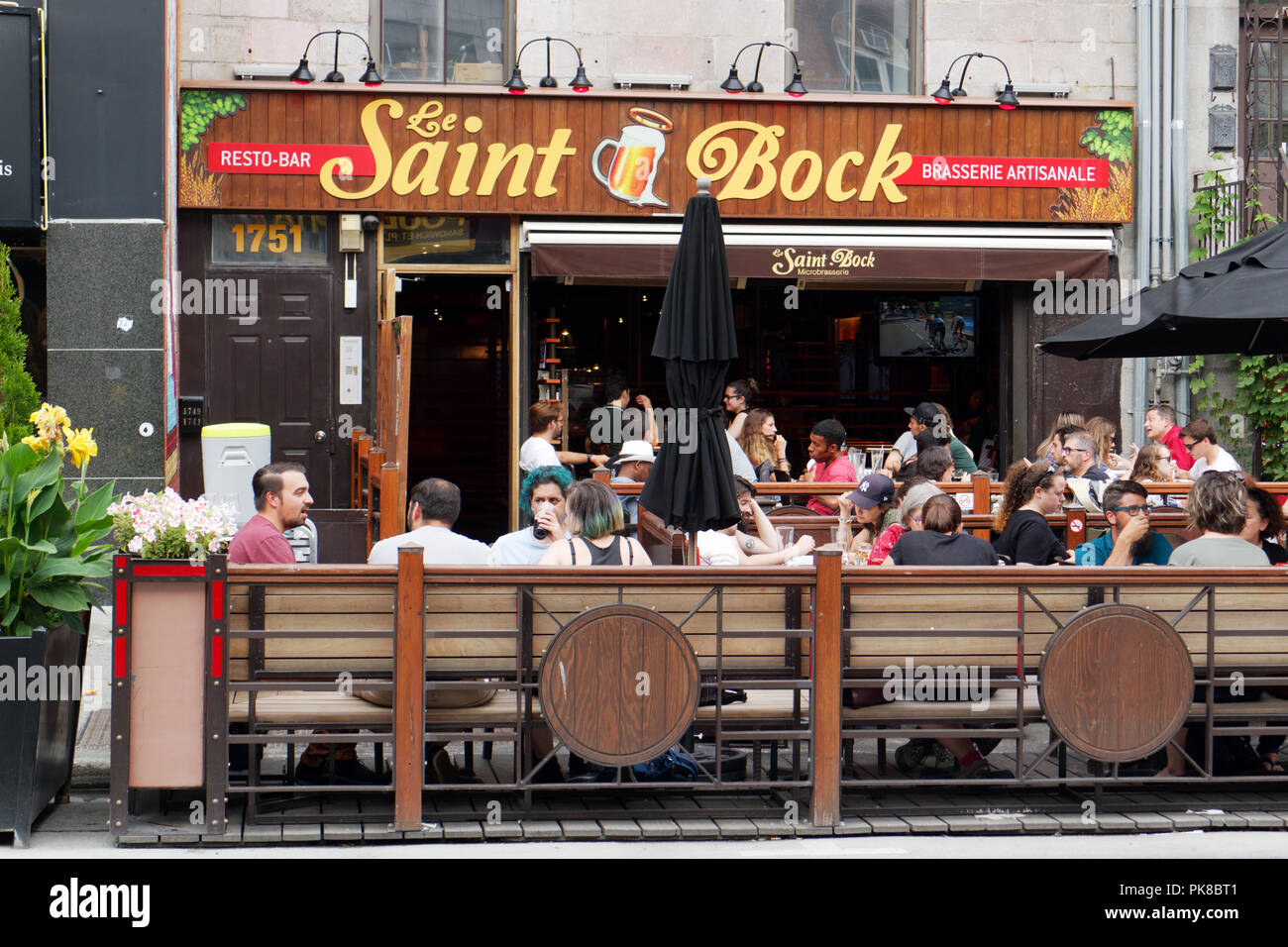 Les gens assis sur la table à l'extérieur de la microbrasserie pub Saint Bock et sur la rue St Denis à Montréal Banque D'Images