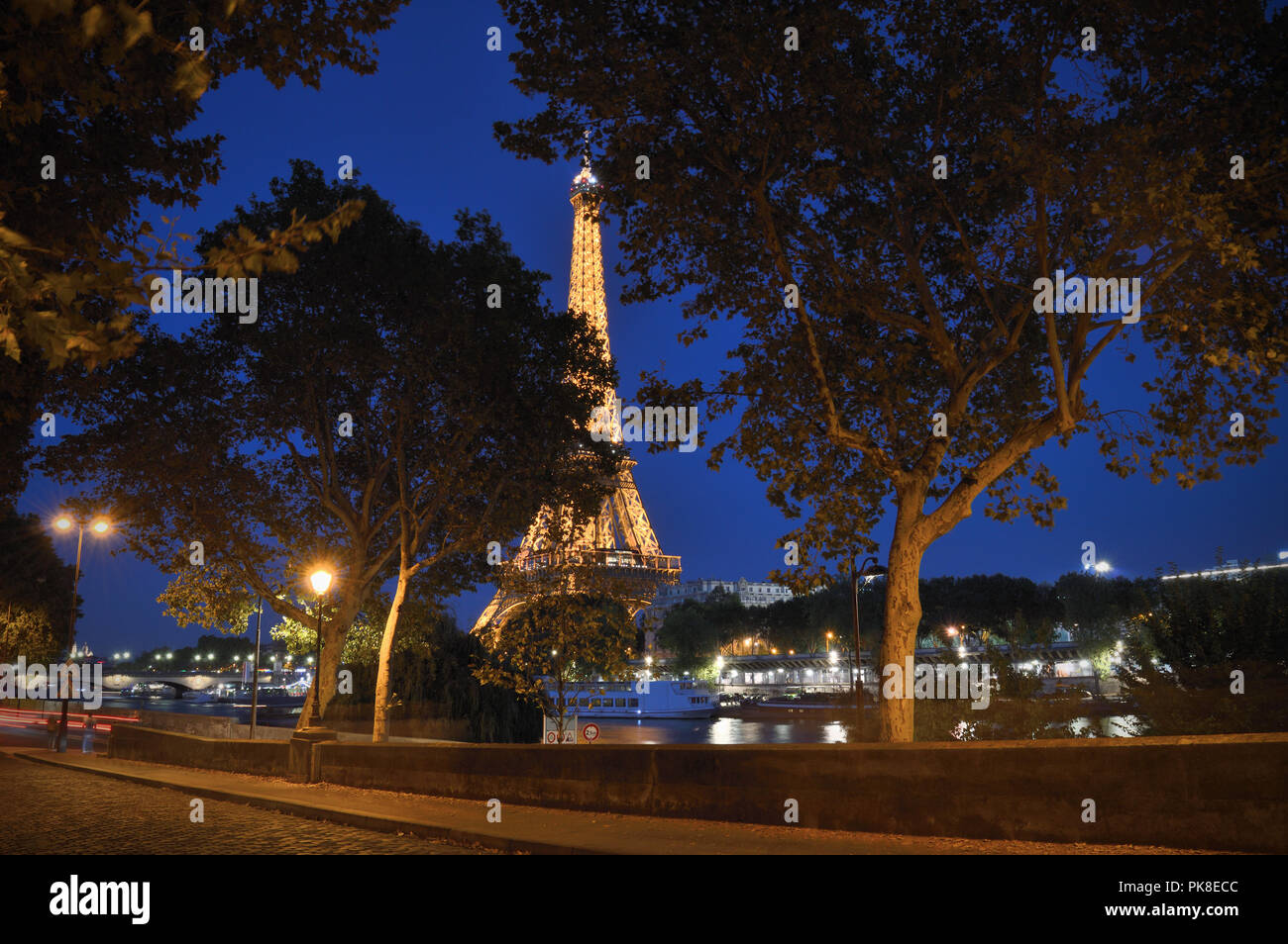Quay à Paris de nuit contre une Tour Eiffel en arrière-plan. Banque D'Images