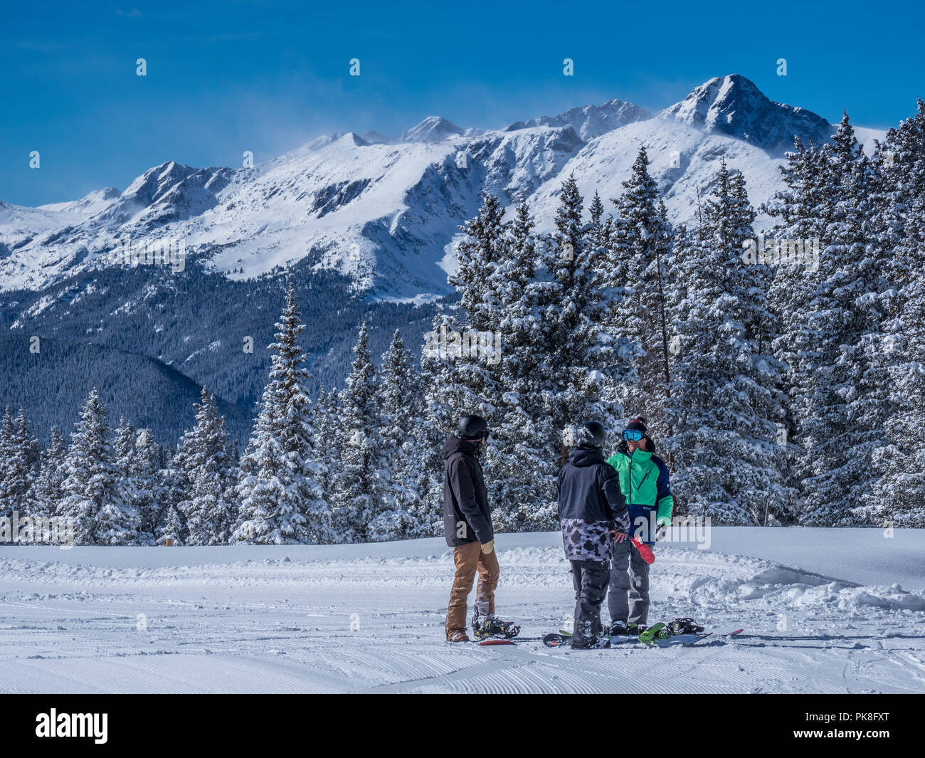 Les snowboarders avec le Mont de la Sainte Croix derrière eux, Belle's Camp, Blue Sky Basin, hiver, station de ski de Vail, Vail, Colorado. Banque D'Images