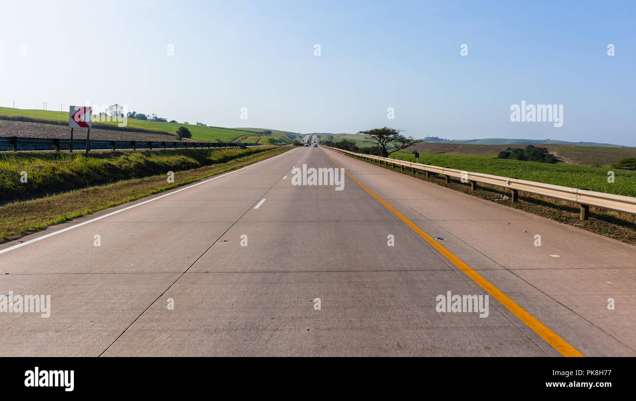 Autoroute Route véhicules voyageant avec le passager voir la perspective avec des terres agricoles pittoresques paysages. Banque D'Images