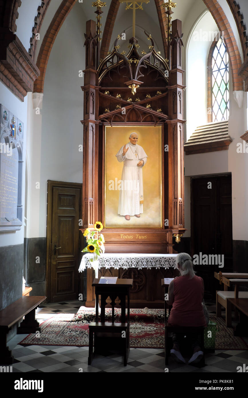 Bialystok Pologne femme priant devant une peinture du Pape Jean II à l'intérieur de la cathédrale de Bialystok Banque D'Images