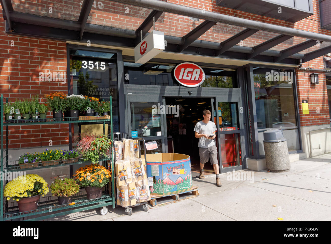 Jeune homme sortant d'un supermarché IGA magasin sur la 4e Avenue Ouest, à Vancouver, Colombie-Britannique, Canada Banque D'Images