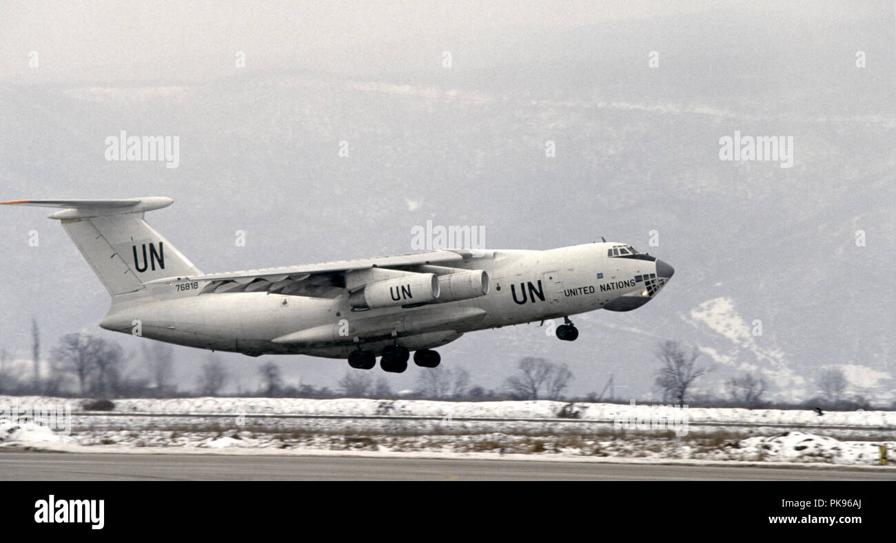 8 mars 1993 pendant le siège de Sarajevo : à l'aéroport de Sarajevo, un Iliouchine 76 de l'Organisation des Nations Unies jet transport décolle. Dans l'arrière-plan, sous l'ombre du mont Igman, sont des bâtiments détruits à la périphérie du village de Butmir. Banque D'Images