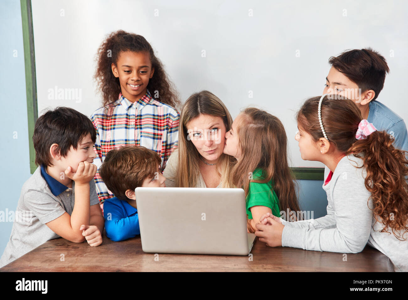 Petite fille donne à son professeur un baiser dans la leçon d'informatique Banque D'Images