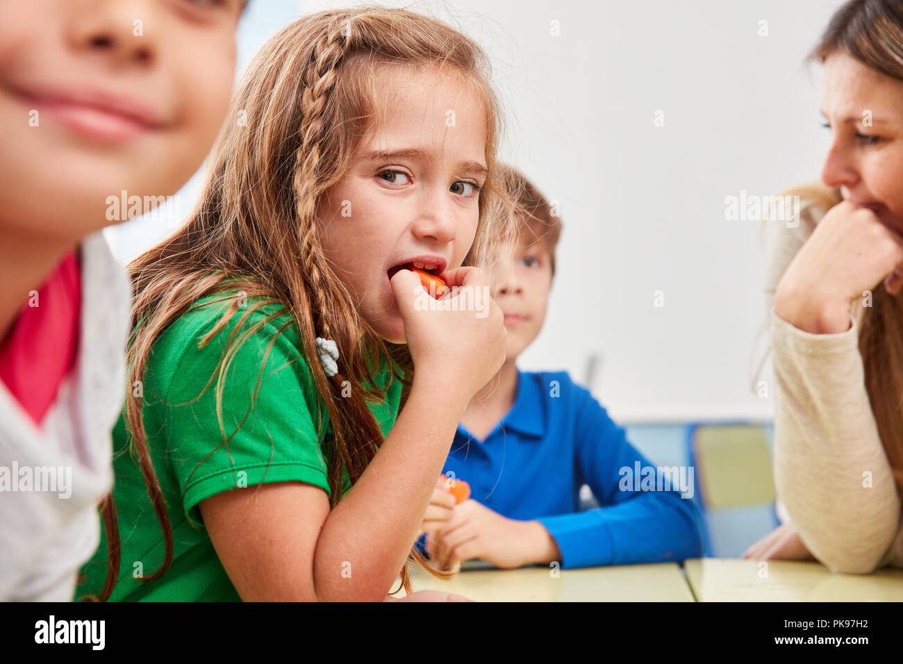 Fille est des légumes sains pour le petit déjeuner à la cantine de l'école élémentaire Banque D'Images