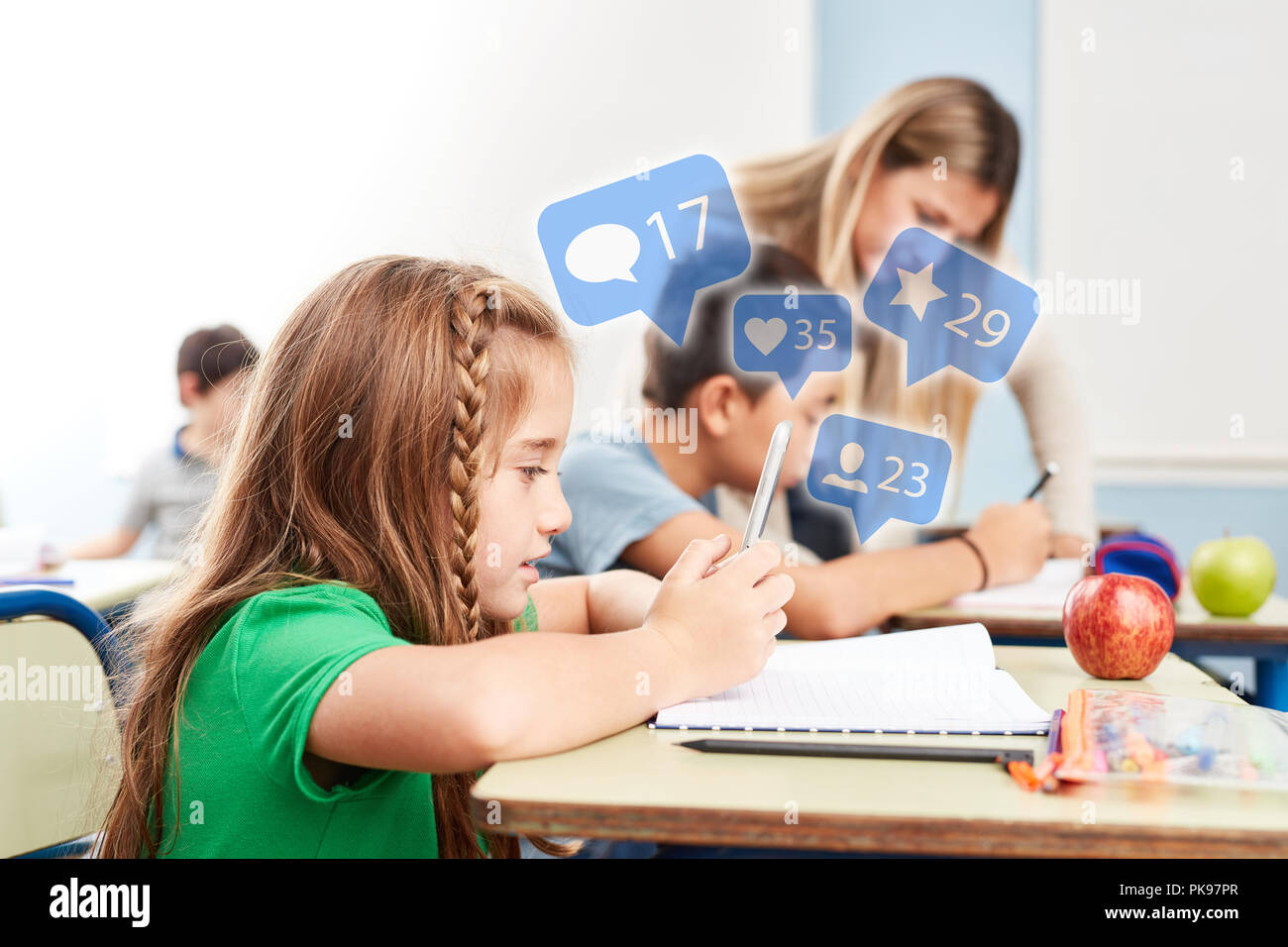 Internet médias sociaux à l'école primaire des leçons avec girl sur smartphone Banque D'Images