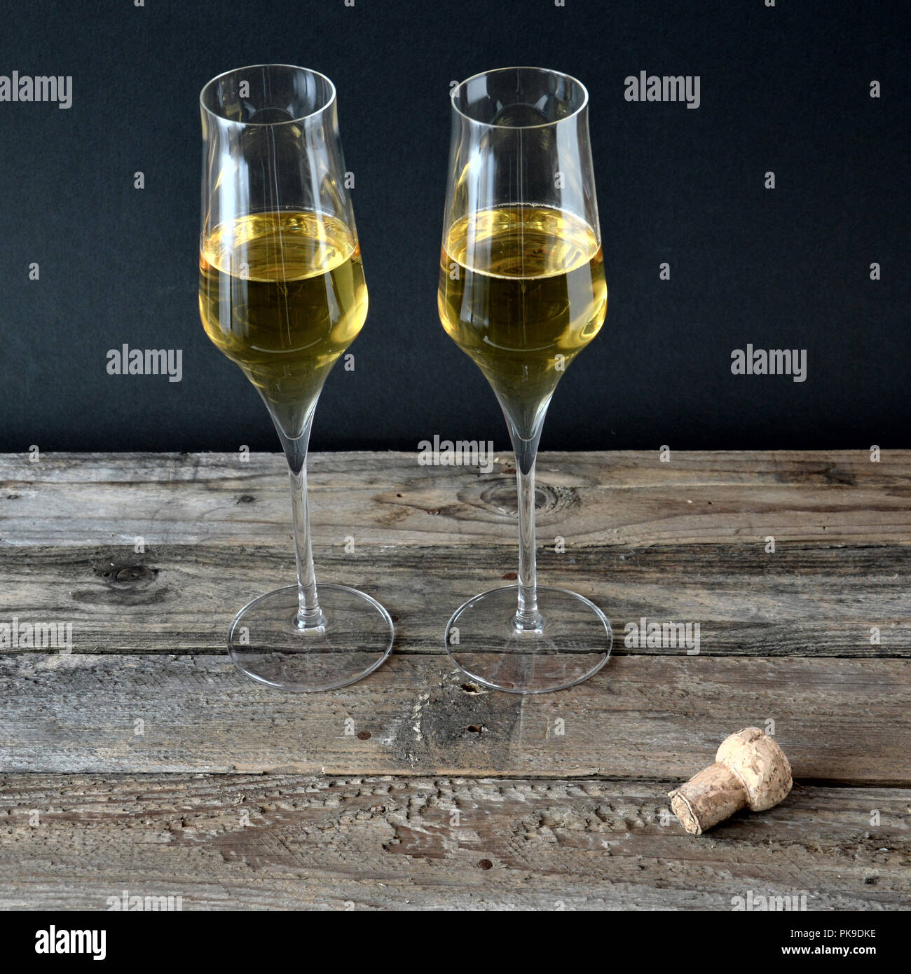 Deux verres de vin mousseux avec bouteille sur avion en bois Banque D'Images