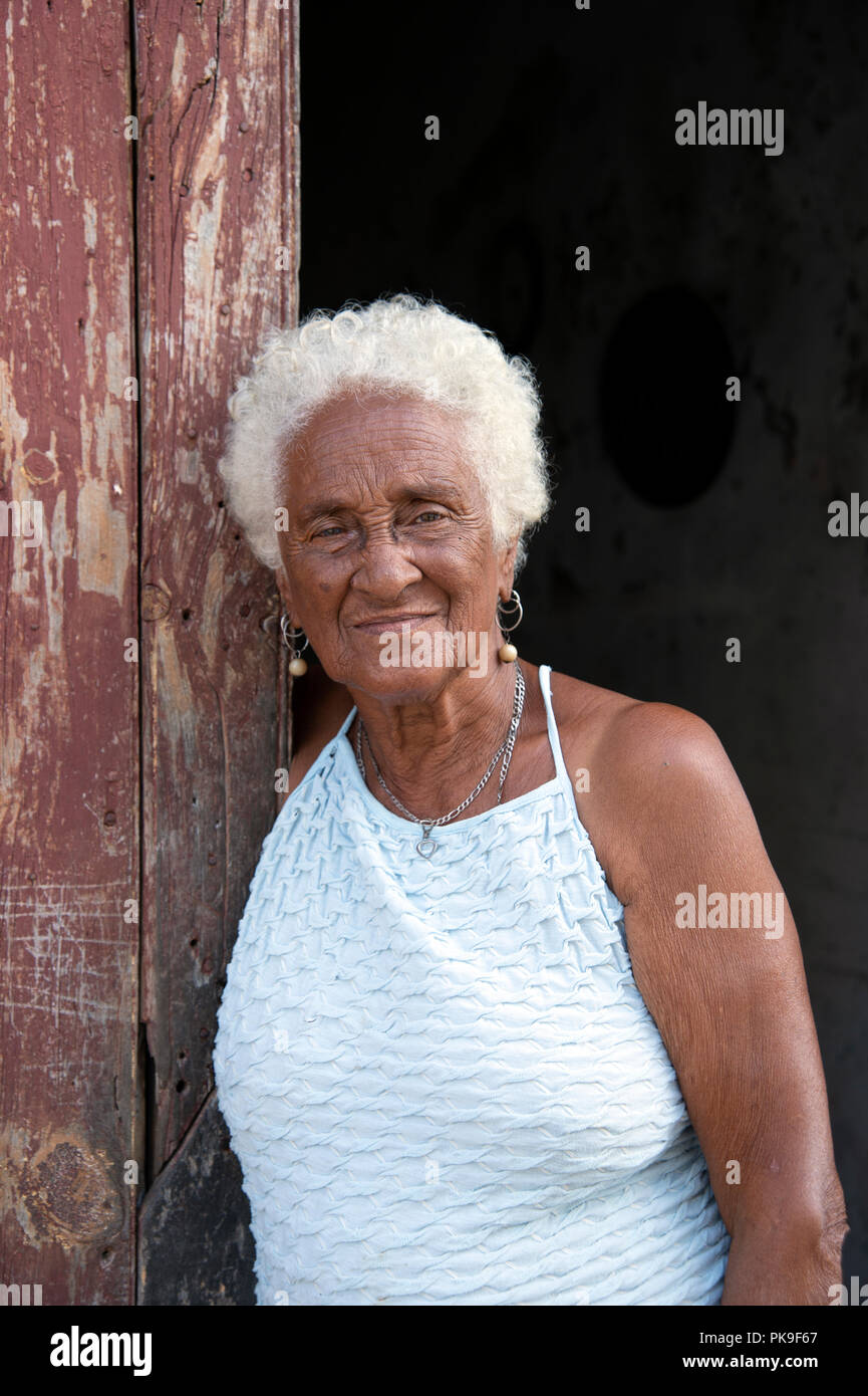 Portrait vertical d'une vieille dame cubaine souriante debout dans la porte de sa maison Banque D'Images