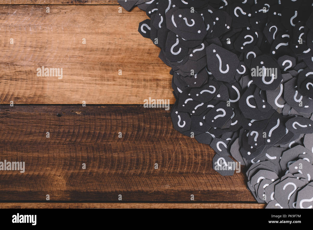 Tas de papier noir avec un point d'interrogation sur la table en bois. Concept de problème, FAQ, Questions-réponses et questions Banque D'Images