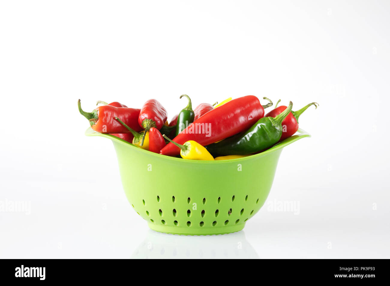 Capsicum annuum. Les piments verts dans une passoire. Banque D'Images