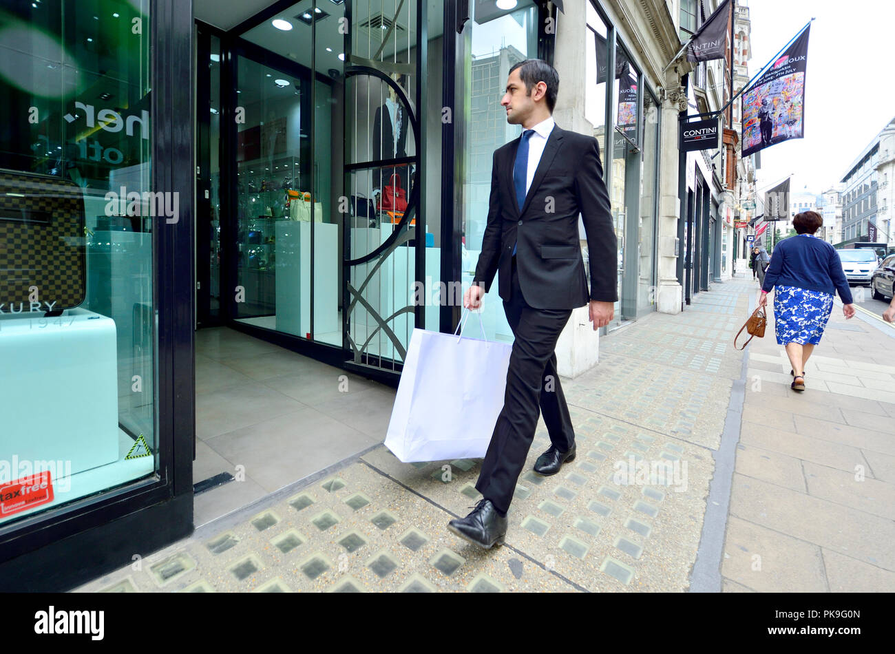 Bien-habillé man shopping in New Bond Street, London, England, UK. Banque D'Images
