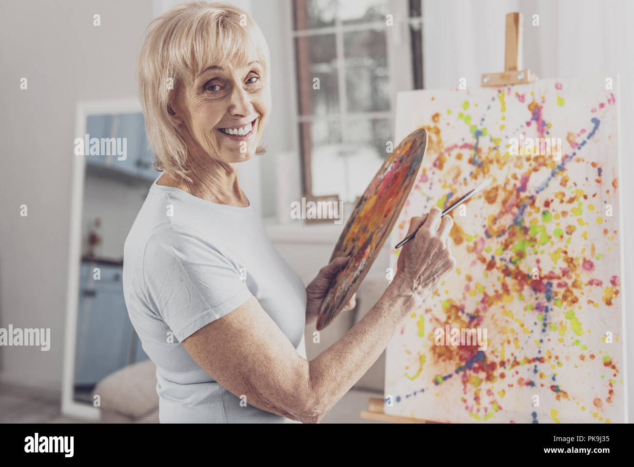 Femme souriante avec les rides du travail avec pinceau peinture Banque D'Images