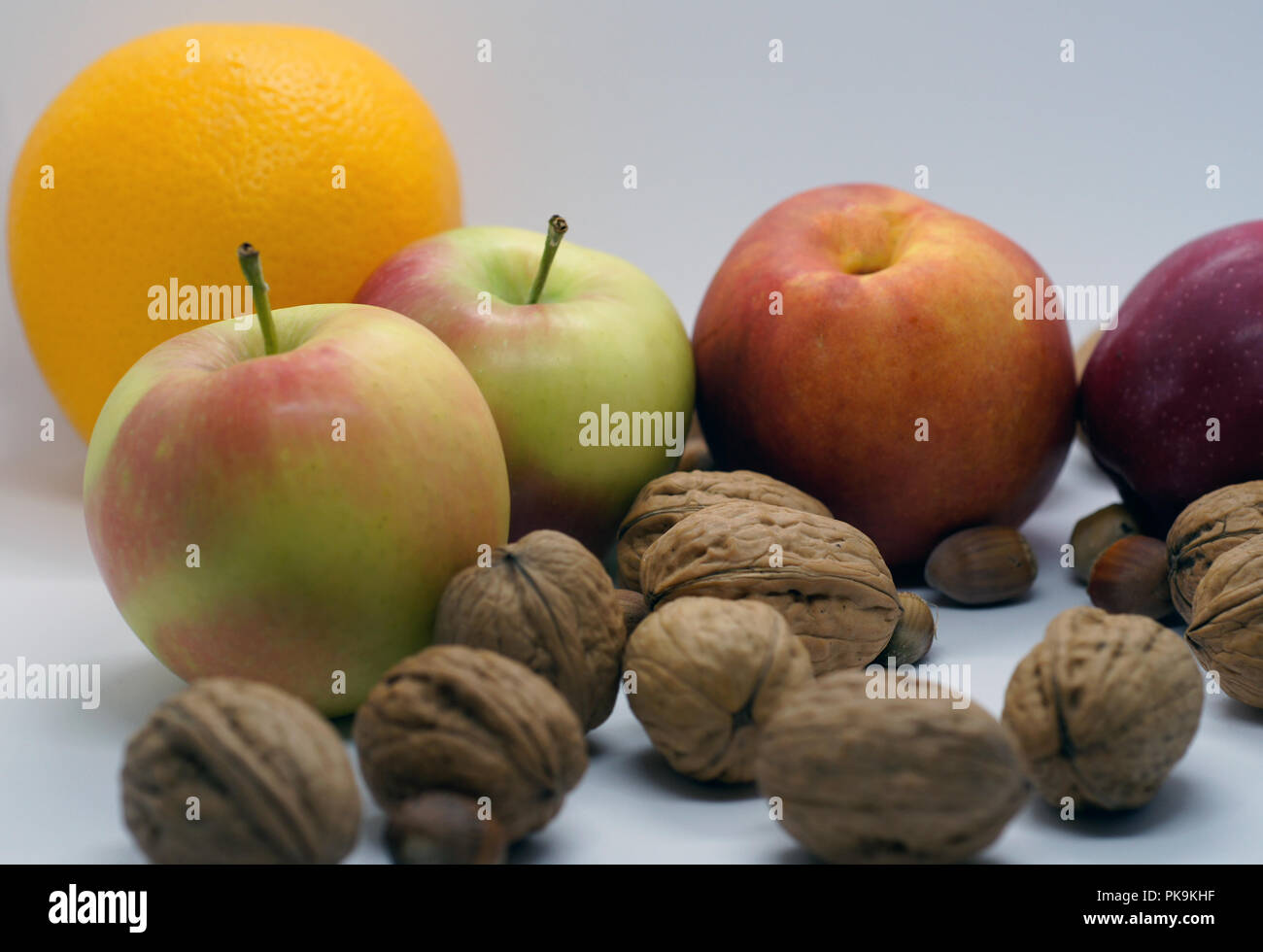 Les pommes, noix et orange Banque D'Images