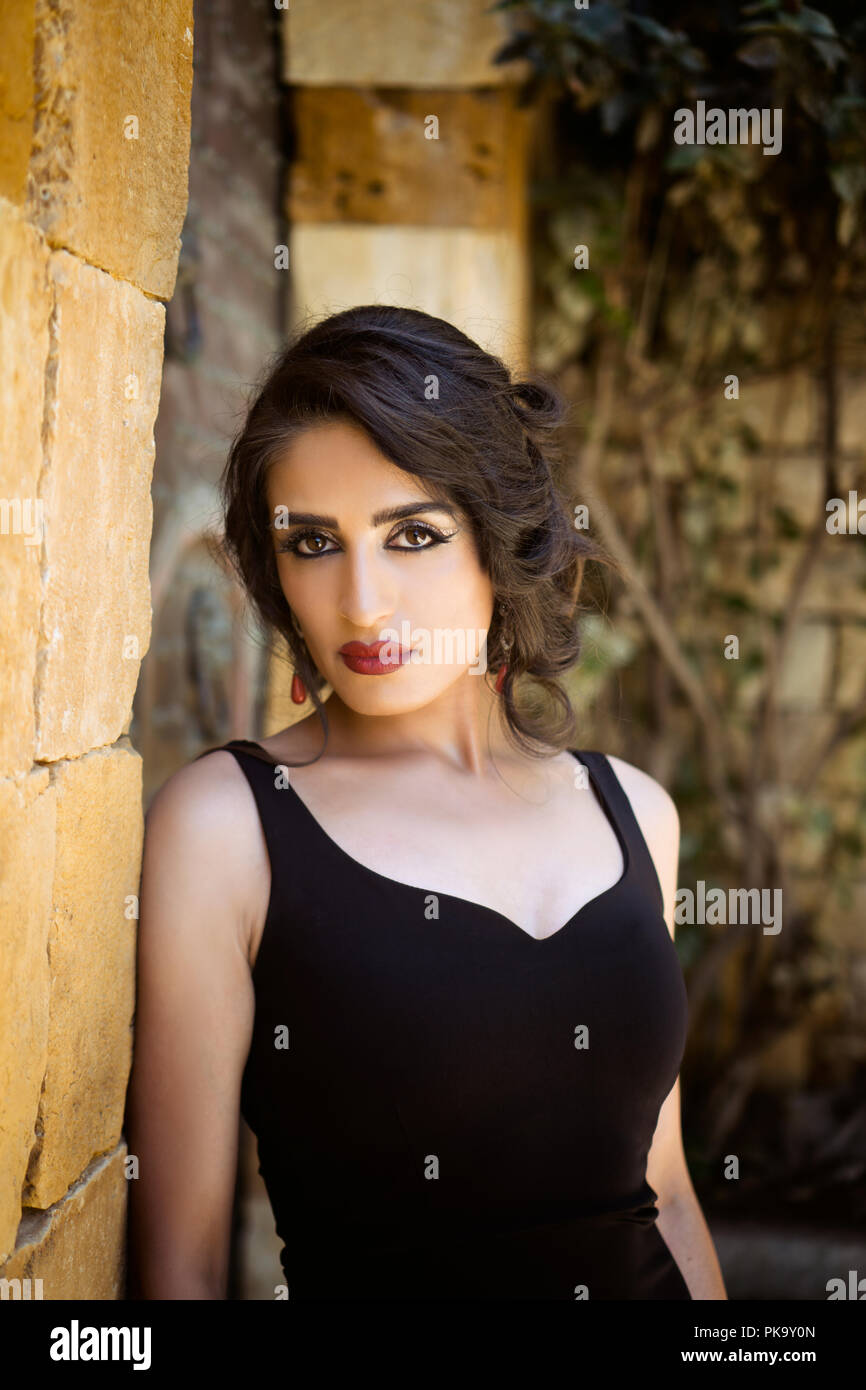 Beautiful woman leaning against wall outdoors Banque D'Images