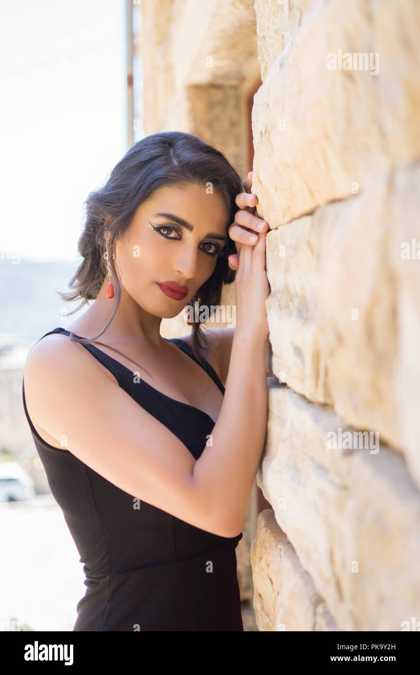 Beautiful woman leaning against wall outdoors Banque D'Images