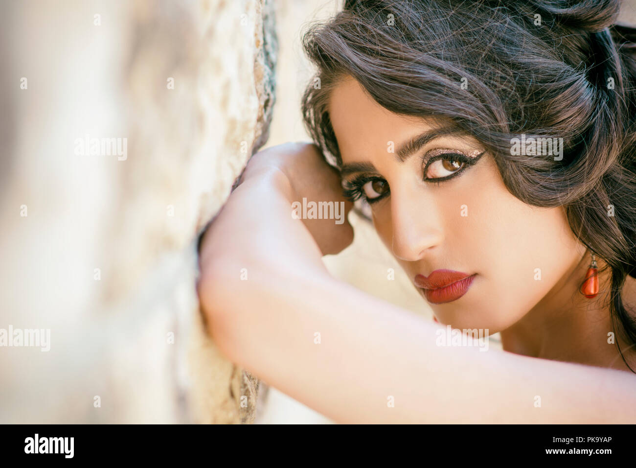 Beautiful woman leaning against wall Banque D'Images