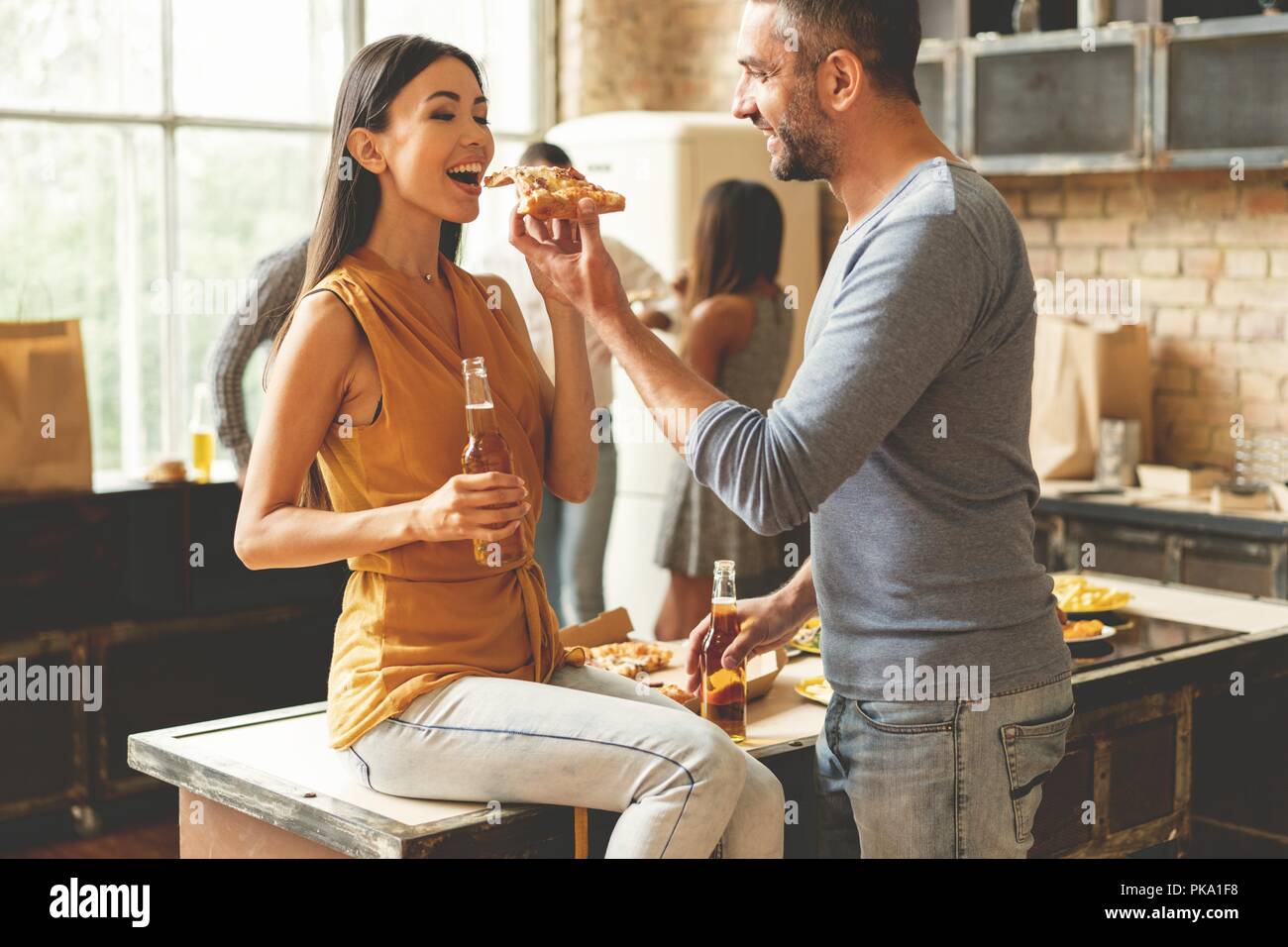 Beau jeune couple est l'alimentation de l'autre et souriant. Banque D'Images