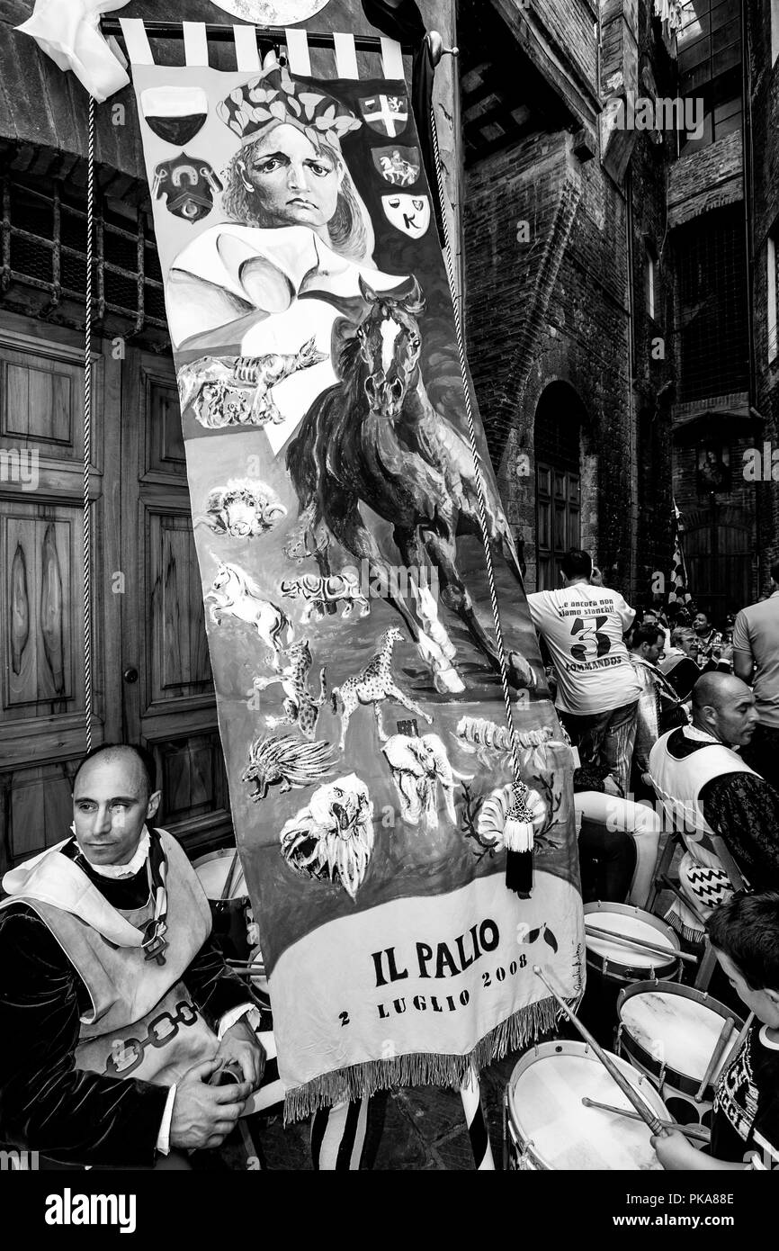 Les membres de l'Istrice victorieux via Prendre un repos qu'ils défilent leur prix d'une bannière de soie dans les rues de Sienne, Palio di Siena, Italie Banque D'Images