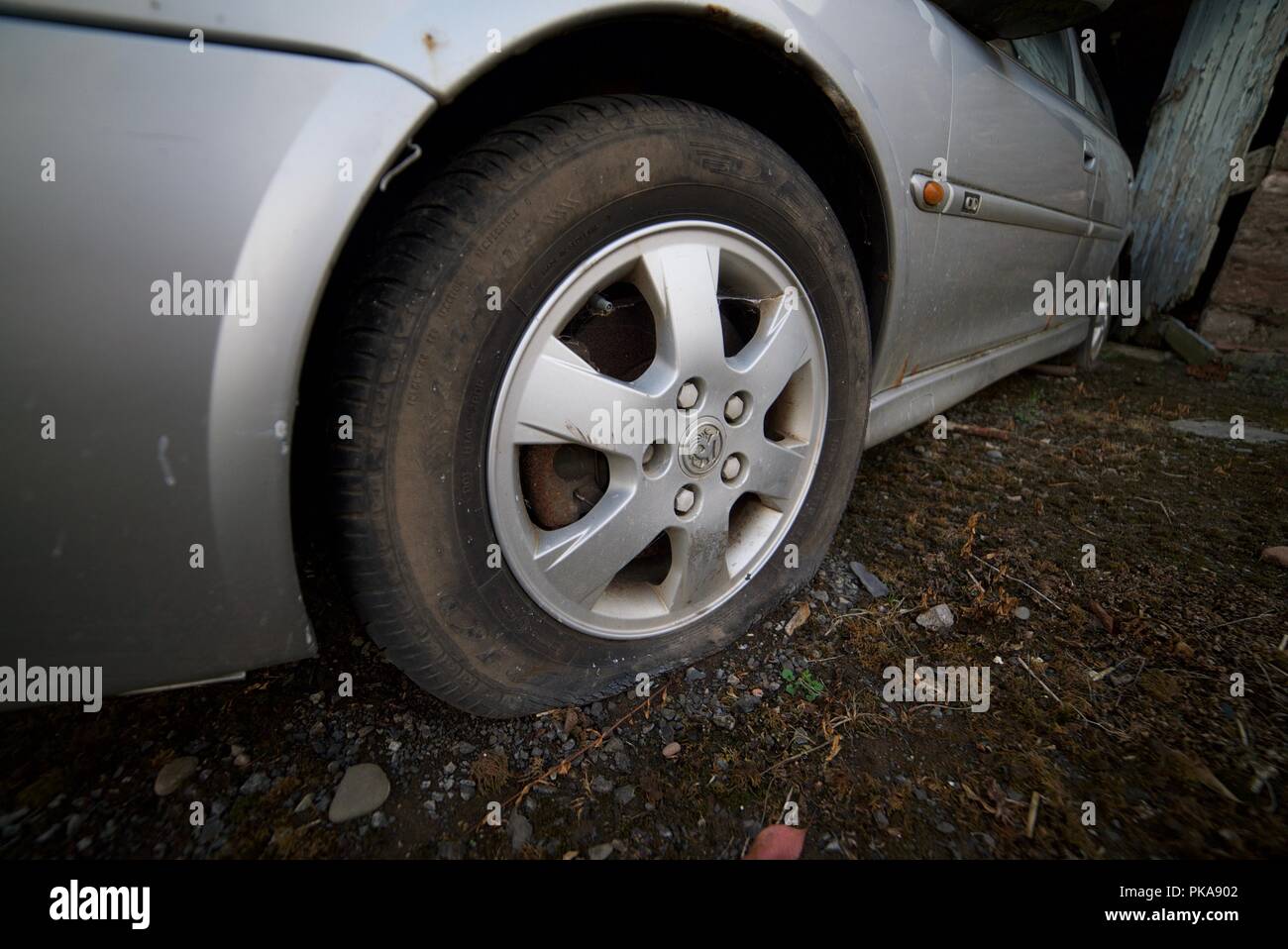 Pneu éclaté sur une voiture (vauxhall voiture avec pneu avant dégonflé de  crevaison Photo Stock - Alamy