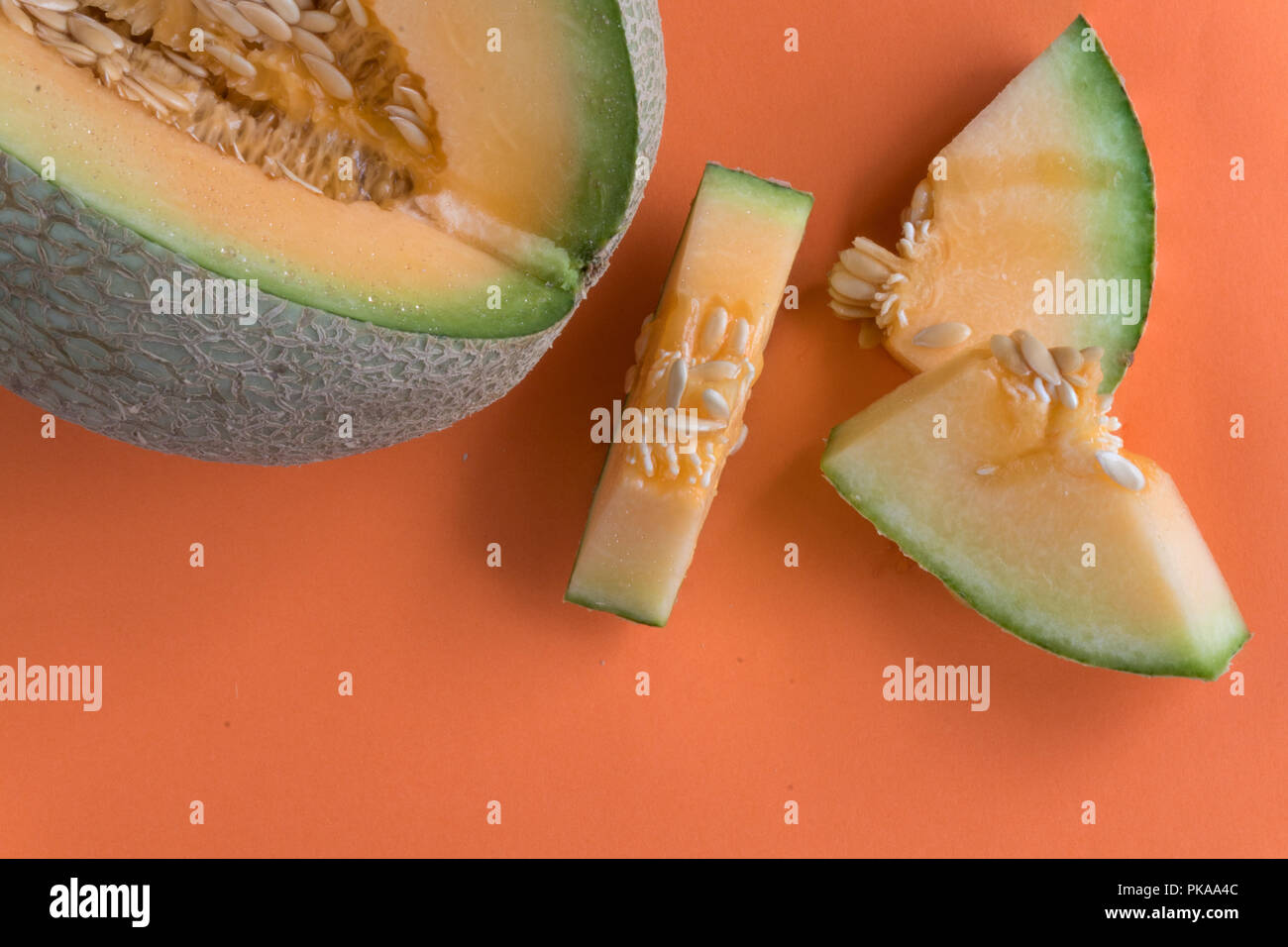 Tranches de melon sur fond orange. Doux, juteux, fruits collation idéale pour suivre un régime sain. Banque D'Images