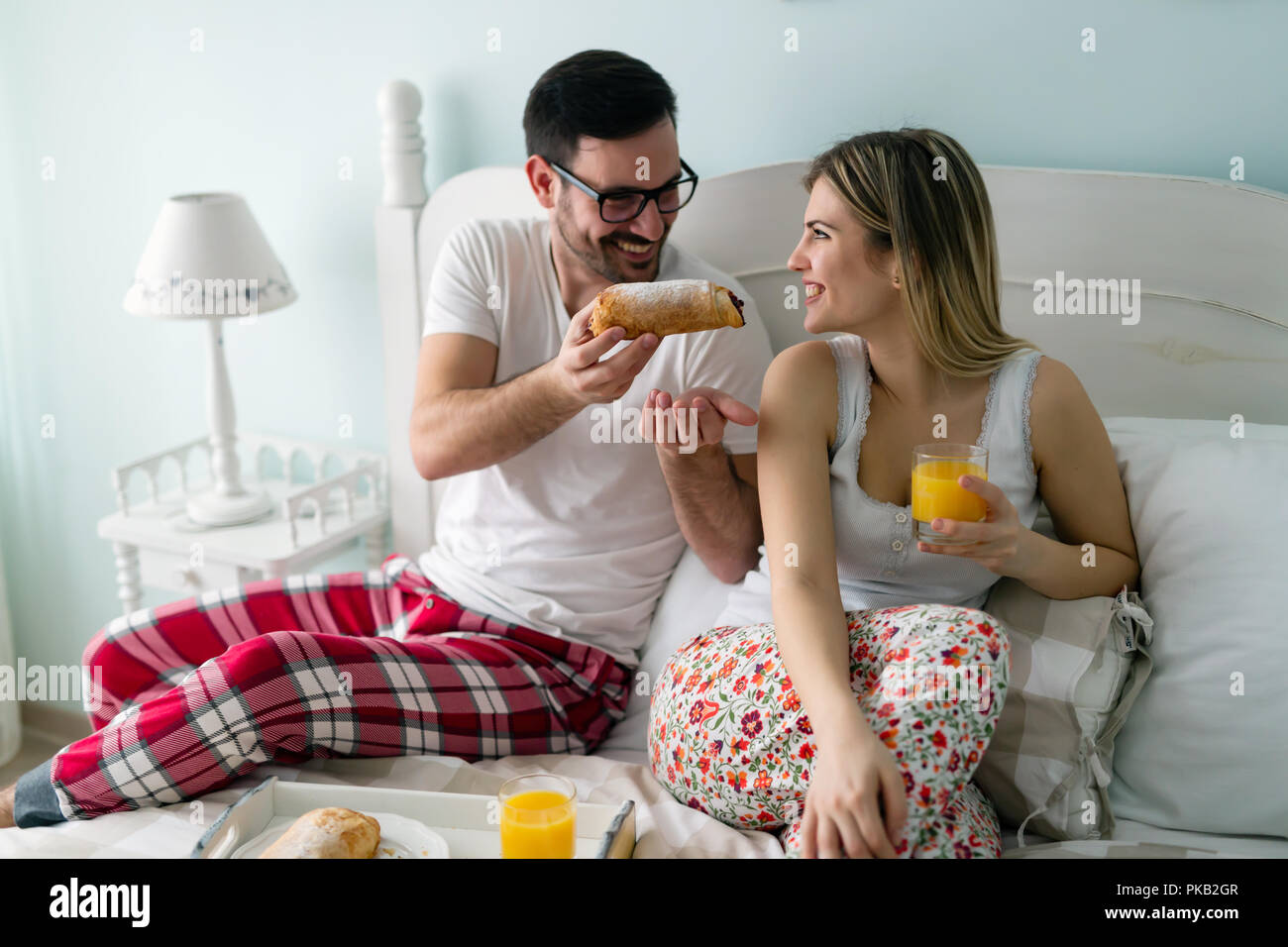 Young attractive couple having breakfast in bed Banque D'Images