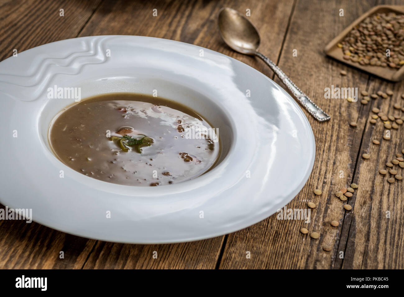 Lentilles brunes avec saucisse sop sur table en bois Banque D'Images