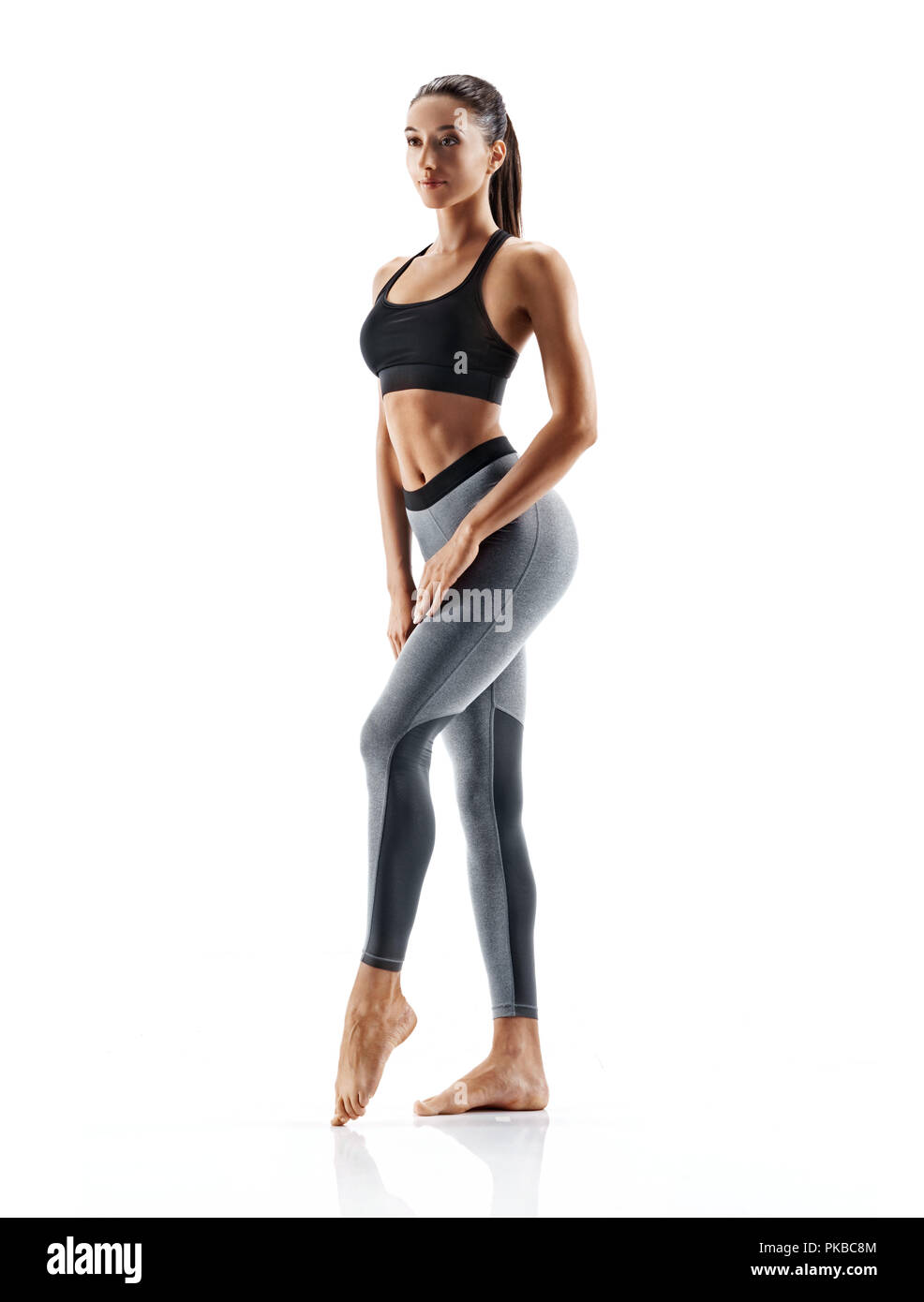 Jeune fille en slim sportswear isolé sur fond blanc. Concept de vie en bonne santé et équilibre naturel entre le corps et le développement mental. Leng plein Banque D'Images