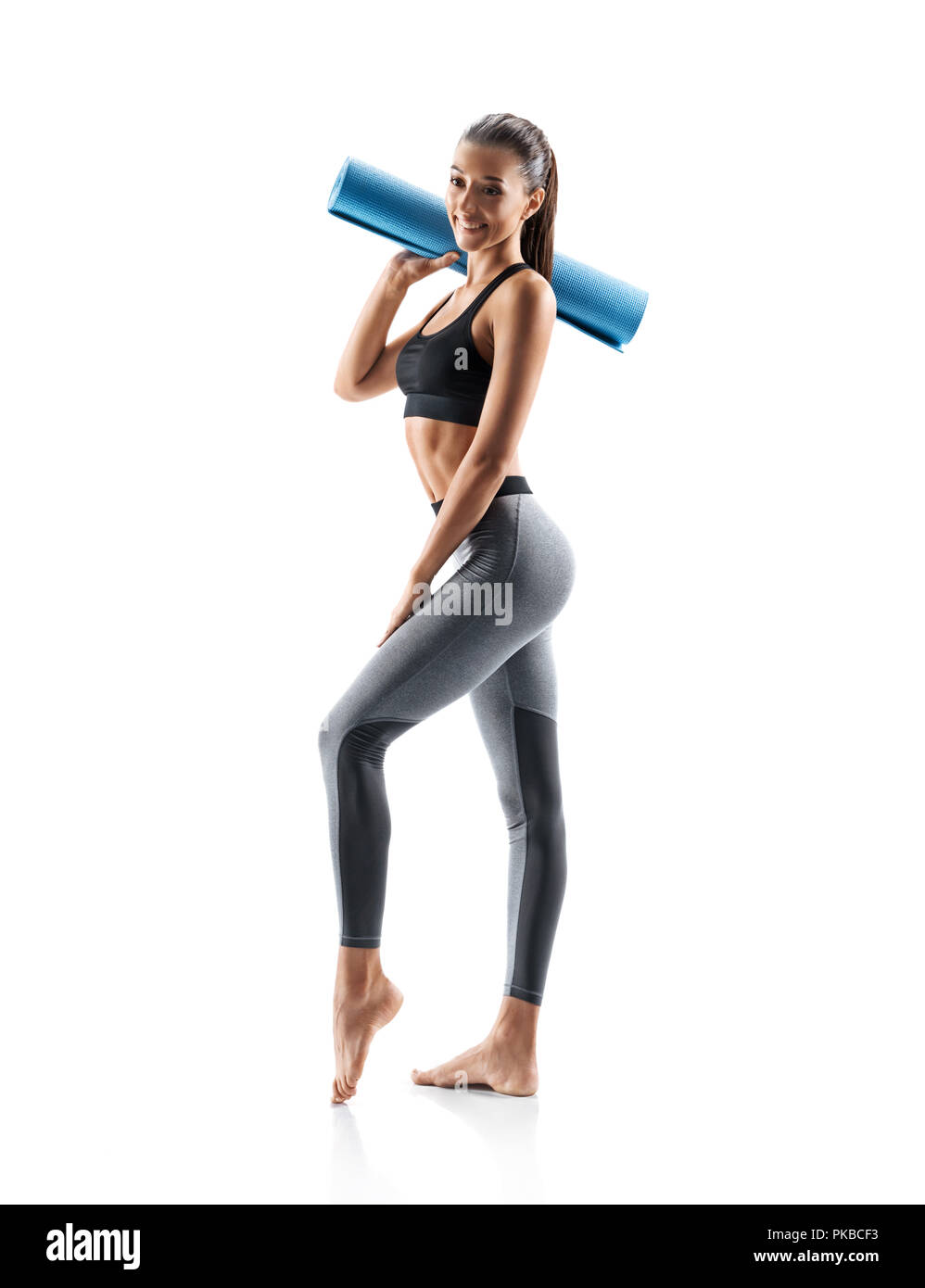 Jeune fille sportive avec un tapis de yoga article isolé sur fond blanc. Concept de vie en bonne santé et équilibre naturel entre le corps et au développement mental Banque D'Images