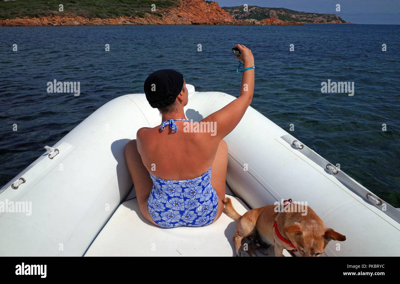 Jeune femme prend un à bord selfies un bateau gonflable dans la mer de Sardaigne Banque D'Images