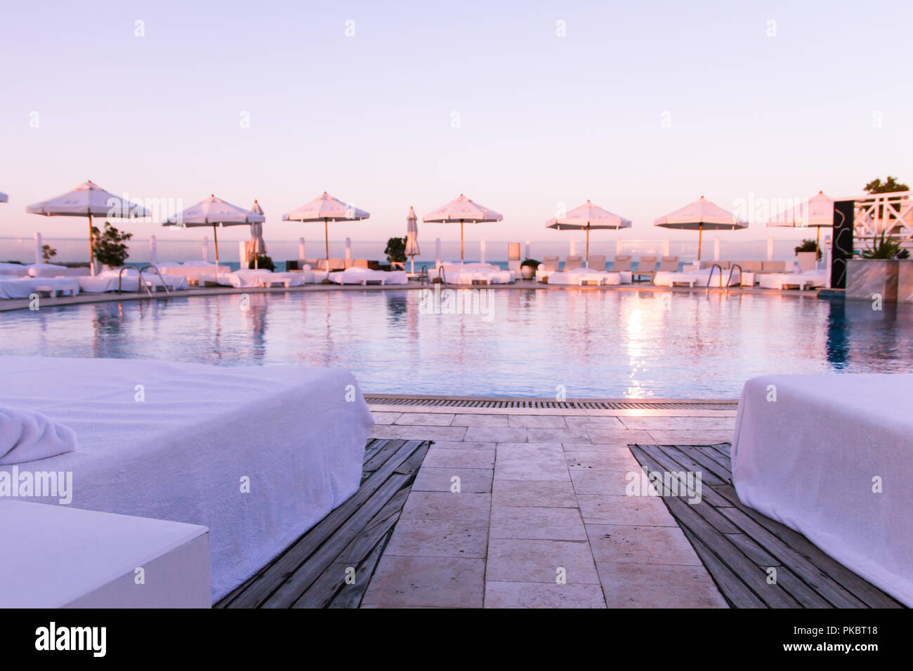 Coucher de soleil Pastel Lumière sur piscine et bains de soleil Banque D'Images