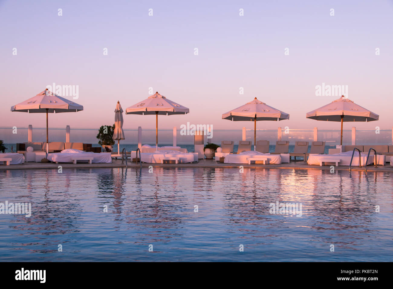 Coucher de soleil Pastel Lumière sur piscine et bains de soleil Banque D'Images